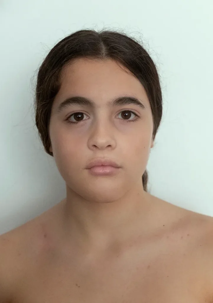 Family mix: retrato frontal de una niña sobre fondo claro